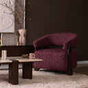 Fauteuil Juun bordeaux met donker beukenhouten frame in een sfeervolle woonkamer