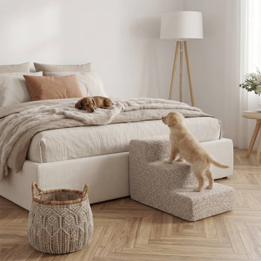 Beige hondentrap in bouclé naast bed, pup loopt naar boven