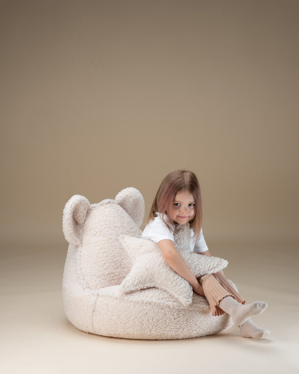 Wigiwama Teddy Star Cushion Creamy white in een kinderkamer