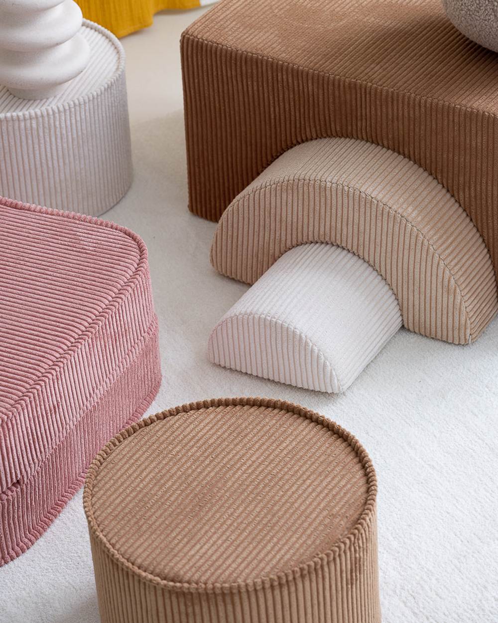 Wigiwama Runder gerippter Pouf Toffee in een kinderkamer